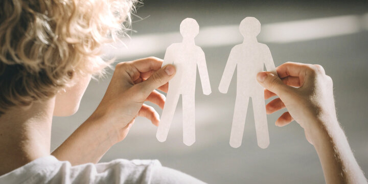 Gender equality with people holding two cardboard cutouts of men representing gay or LGBTQ relationships