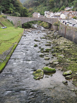 Rocky waters of the River Lyn flowing beneath a stone arch bridge in Lynmouth, North Devon, site of the tragic 1952 flood disaster in Exmoor National Park, UK