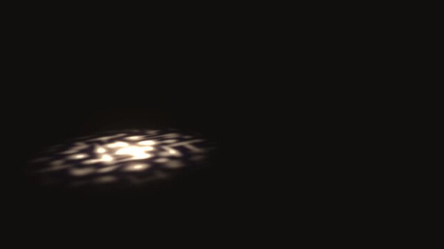 Spotlight caustic light beam projects an illuminated organic oval pattern onto a dark floor surface in a 3D animation