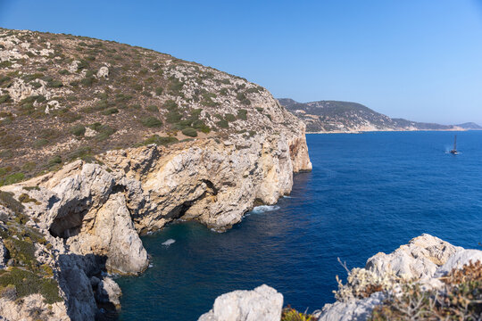 Natural cliffs, blue waters, and a serene sky. Ideal for concepts of solitude, exploration, and natural beauty in coastal and marine landscapes. A rugged coasts of Patara beach, Turkey