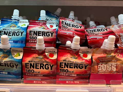 A shelf filled with colorful energy drink packets. The packages display different designs and nutritional information. Bright colors dominate the packaging, emphasizing the energetic theme.