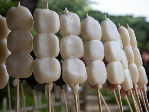Traditional Japanese dango skewers with white mochi rice dumplings selling outdoors