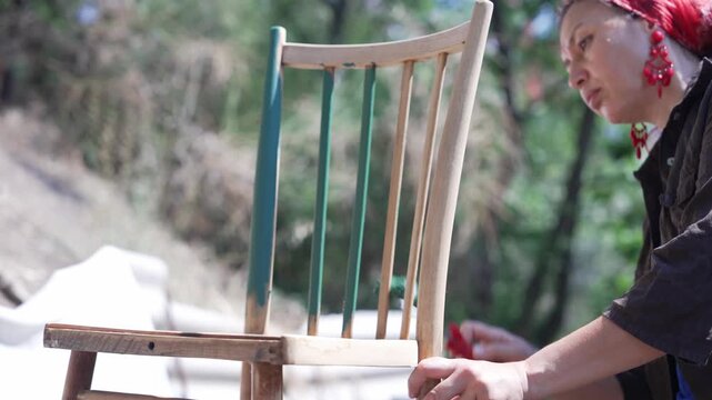 Woman Upcycling an Old Chair with Paint