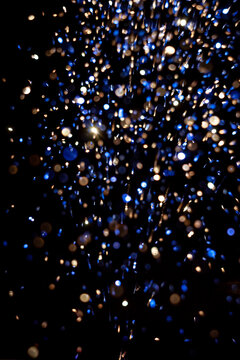 Bright sparks flying in a dark setting during a celebration with colorful lights and a festive atmosphere