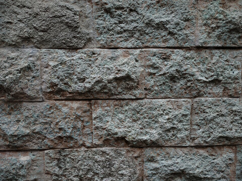 Rough gray stone wall texture pattern with rough-cut blocks, ideal background or overlay for design projects