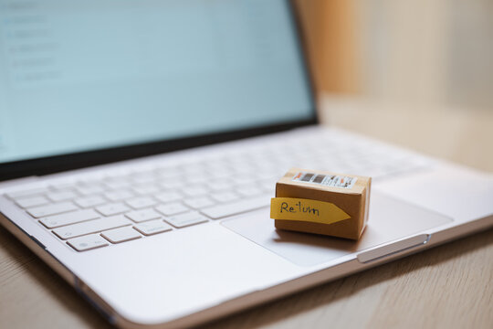 A packed carton rests as online and return and product and parcel and refund lead, then online and return and product and parcel and refund lead the buyer's decision at a desk nearby in close detail.