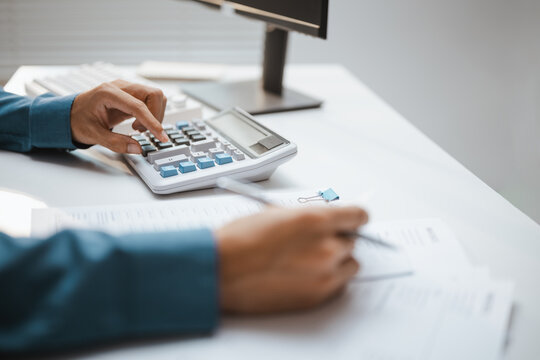 Number pad shows using a calculator budget calculating tax entries, then shows using a calculator budget calculating tax entries in a dim warm soft calm quiet bright sunlit natural gentle muted room.