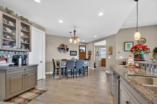 Cozy modern kitchen dining area with granite island, pendant lights, and holiday decor warm ambience