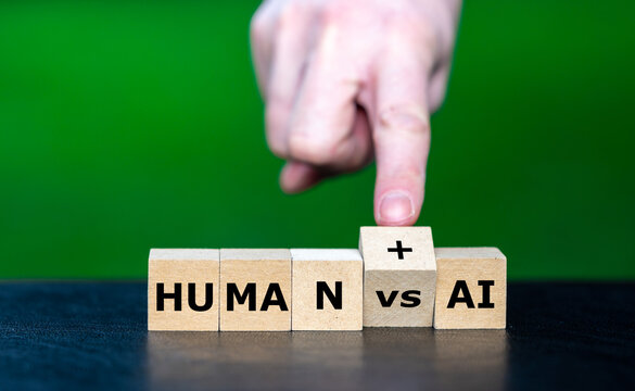 A hand changes VS to a plus sign between HUMAN and AI, symbolizing a shift from competition to human and artificial intelligence collaboration.