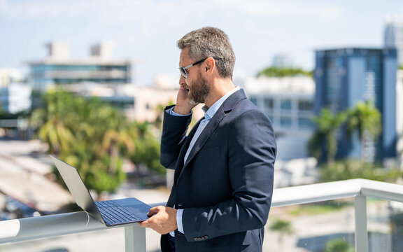 Successful businessman freelancing online. Hispanic business man working online. Remote working. Phone call communication. Businessman busy working on laptop outdoor. Man has business phone call