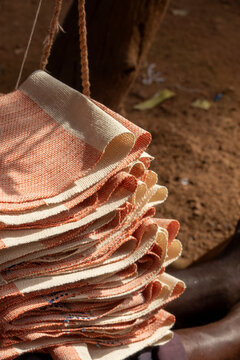 Folded Senufo cotton cloths hang on cords ready for sale at a street market, Savanes district, Waraniene, Ivory Coast