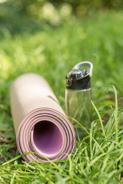 Yoga Mat and Reusable Water Bottle on Grass for Fitness and Wellness