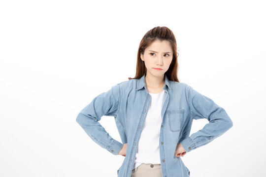 Frustrated young woman standing with hands on hips isolated on white background
