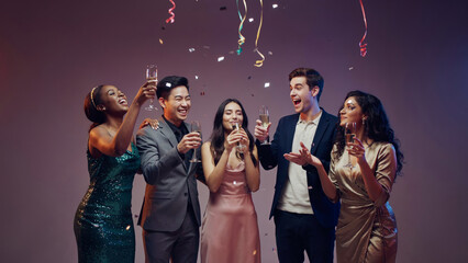 Obraz premium A group of diverse people celebrating with champagne and confetti.