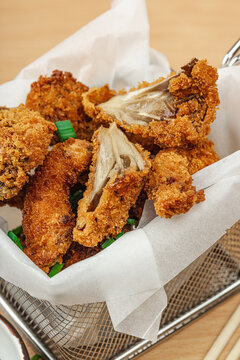 Battered and deep-fried oyster mushrooms (Pleurotus) with dipping sauce and green onion