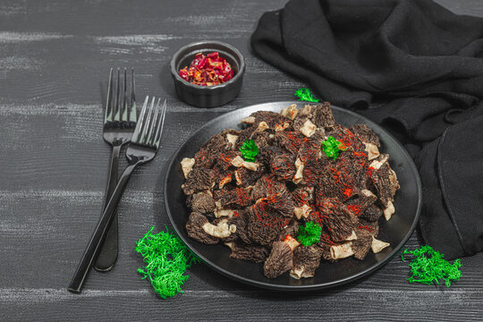 Raw black morel mushrooms with fresh parsley. Vegan ingredient for cooking healthy food