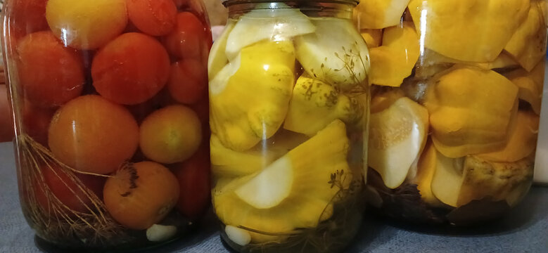 Jars of homemade pickled tomatoes and yellow pattypan squash