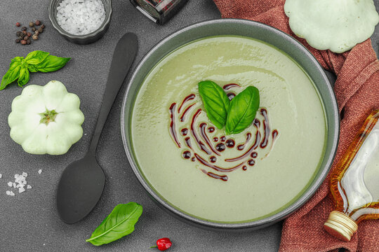 Creamy pattypan squash soup, garnished with basil and balsamic glaze, served in a trendy bowl