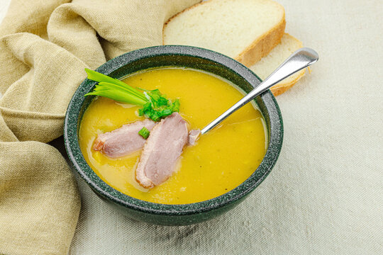 Rustic vegetable lentil soup with smoked duck breast served in a ceramic bowl. Creamy texture