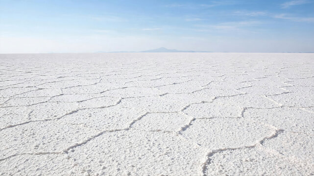 Vast White Salt Flat Desert with Polygonal Cracks Pattern Under Blue Sky