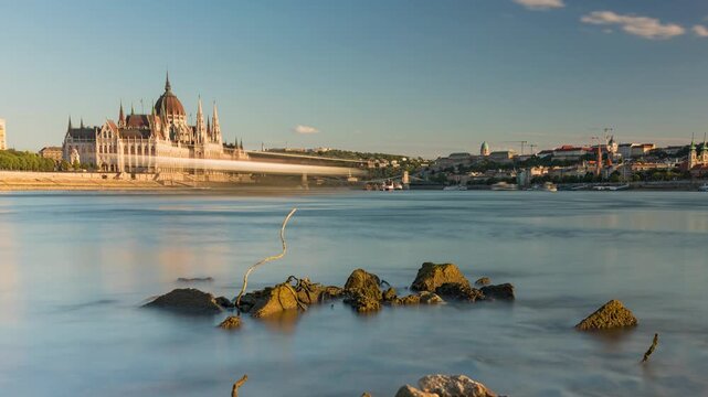 Budapest cityscape timelapse showing dried low water Danube riverbed rocks with dramatic sunset light over Hungarian Parliament Building