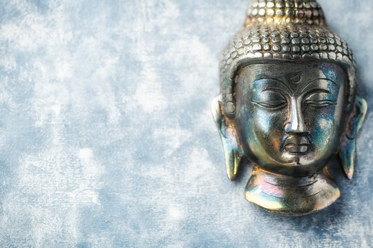 Buddha head on rustic wooden background. Soft focus. Top view. Copy space.