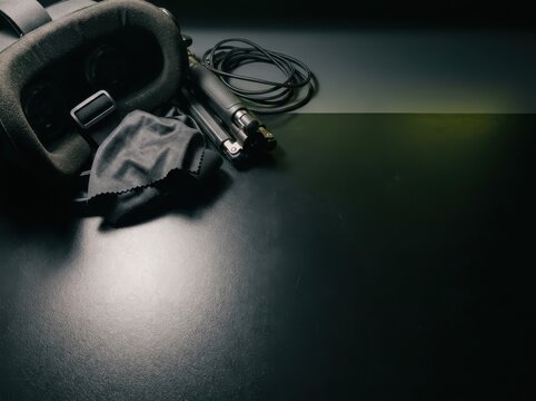 Quiet VR headset on dark desk with cable