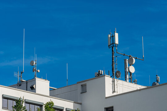 Communication towers on a building under a clear blue sky