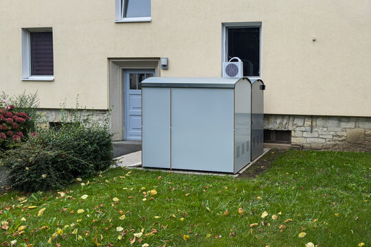 Outdoor storage unit located beside a residential building