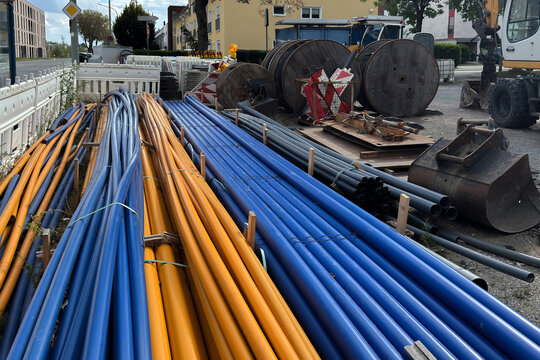Various pipes and cables stored at a work site in an urban area