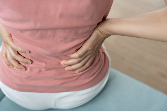 woman holding back while and suffer from unbearable pain health and problems, chronic back pain, backache in office syndrome, scoliosis, herniated disc, muscle inflammation