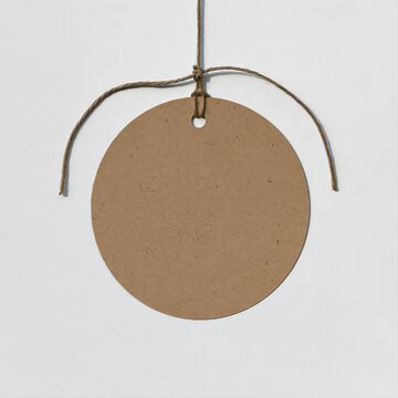 Blank round kraft gift tag with textured recycled paper and twine string, minimalist mockup for label and packaging design with copy space