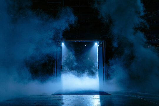 Dramatic blue light and smoke fill a stage entrance, creating an exciting atmosphere.