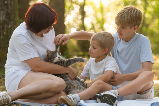 Mother embracing sons in a warm summer forest, showing love, care, and family bond during golden hour