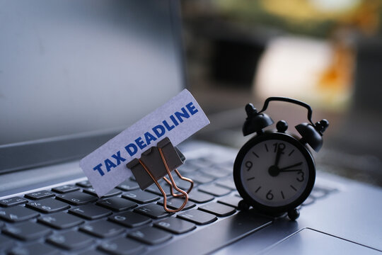 A note reading "TAX DEADLINE" is clipped to the top of the keyboard with a paperclip as a reminder that the tax payment deadline is approaching.