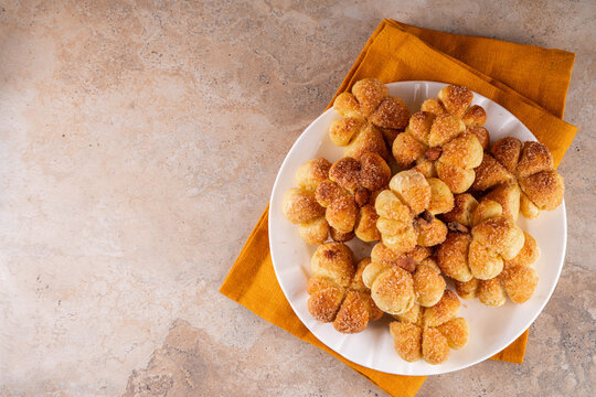 Pumpkin spice buns with almond nuts, cinnamon and sugar crunch. Autumn baking idea, pumpkin puree based vegetable rolls in form of small pumpkins. Tiny sweet pumpkin shaped buns on white plate,