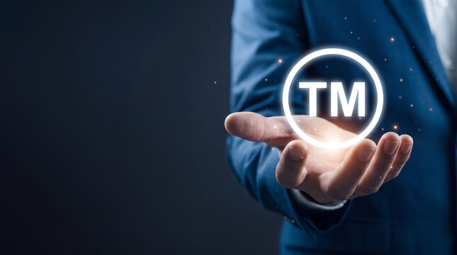 Professional holding glowing trademark TM icon, symbolizing intellectual property, brand protection, legal rights, and corporate identity in modern business.