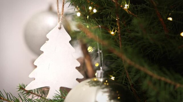 Close-up shots of two boys and their grandmother decorating a Christmas tree indoors. The brothers wear festive hats and pet a black cat near winter ornaments and a toy snowman.