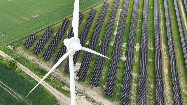 Renewable power plant featuring solar panel farm and wind turbine