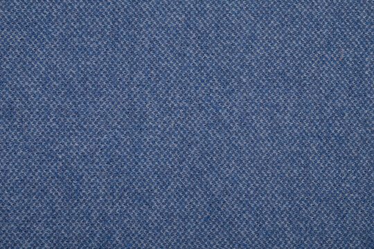 Macro texture of uniform light blue knitted wool fabric with a subtle heathered pattern
