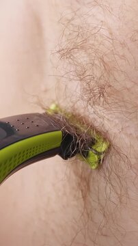 Slow Motion Close Up of a Man Shaving Armpit Hair with an Electric Body Trimmer, Showing Personal Grooming, Hair Removal And Male Hygiene Routine Vertical video.