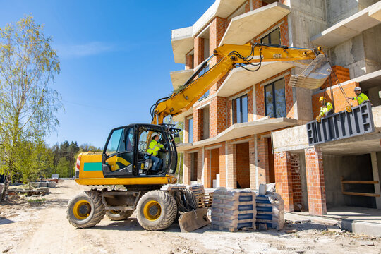 Excavator operator maneuvering machine during formwork installation