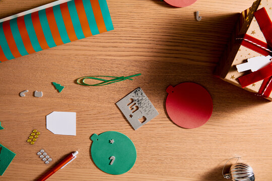 Flat Lay of Christmas Gift Wrapping Materials and Handmade Holiday Craft Accessories on Wooden Table
