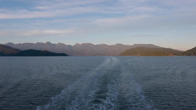 Coast Mountains, Bowen and Gambier Island from the stern of a ship or ferry at golden hour BC< Canada travel and tourism