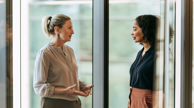 Two Businesswomen Having a Conversation in a Modern Office