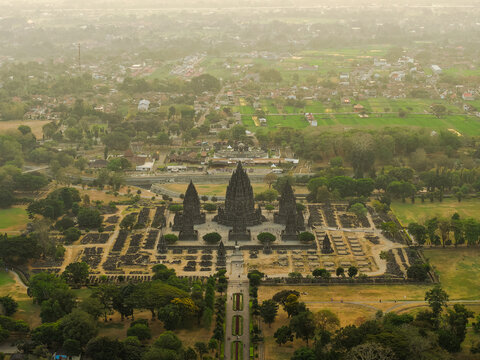 Aerial view of Prambanan Temple with its iconic stone spires surrounded by lush gardens and ancient ruins in Yogyakarta, Daerah Istimewa Yogya, Indonesia.