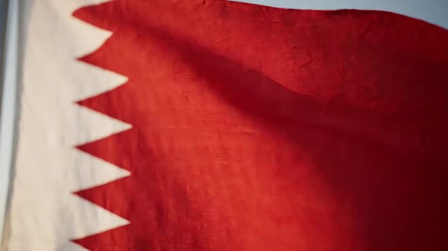 Bahrain flag waving against a clear sky in close up view