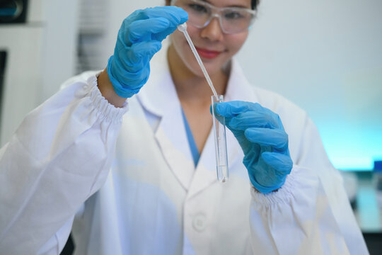 Cropped image of Female Scientist Pipetting Liquid into Test Tube in Modern Laboratory