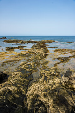 Volcanic rock formations and tide pools stretch along the coastline near El Cotillo, Fuerteventura, Canary Islands, Spain.