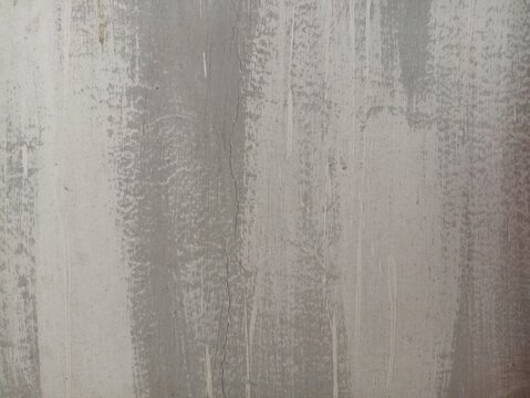 Concrete texture background with distressed grey paint and vertical hairline crack, ideal for minimalist industrial designs, urban posters, and modern backdrops